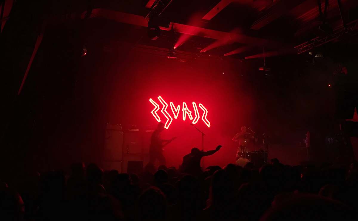 night life Slaves lighted signage on stage crowd